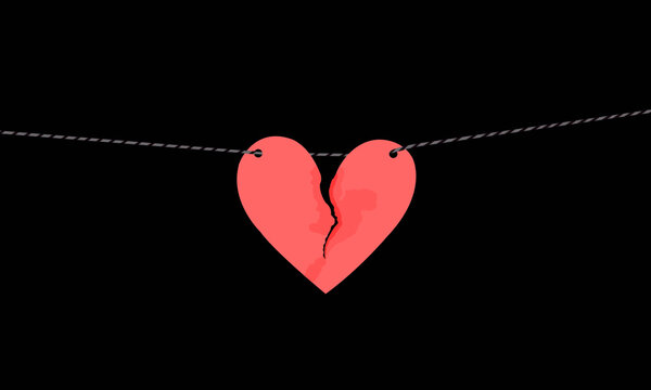 Pink heart shaped paper with torn marks hanging on the rope. Broken heart,unrequited love.