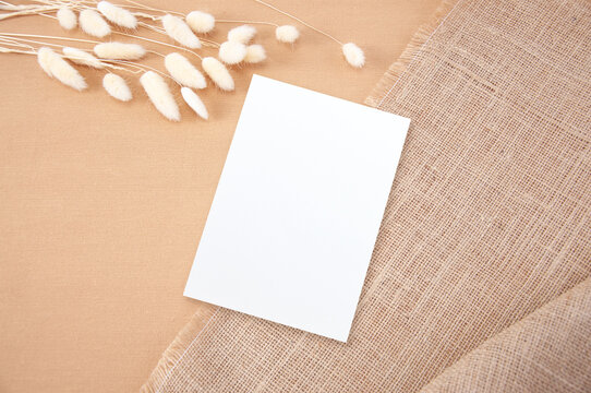 Invitation Mockup. Top view blank card on brown cloth background and flower with clipping path.