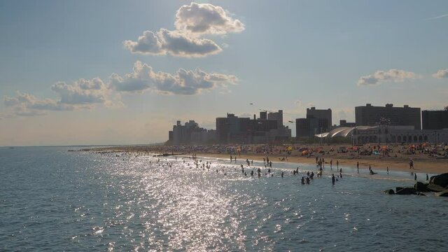 blurry image , unrecognized people at beach ,beach and building skyline of coney island beach NY