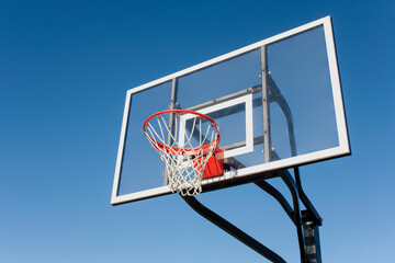 basketball board with hoop against blue sky © psching