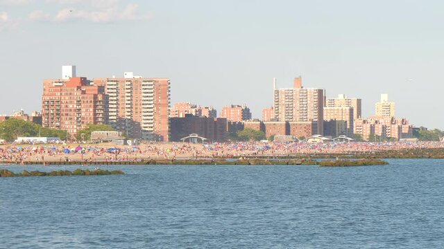 blurry image , unrecognized people at beach ,beach and building skyline of coney island beach NY