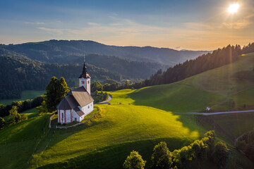 Sveti Andrej, Slovenia - Aerial drone view of Saint Andrew church (Sv. Andrej) at sunset in Skofja...