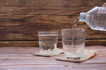 Glasses of water on a wooden table background and space for text
