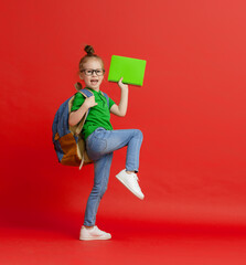 Kid with backpack on color background.
