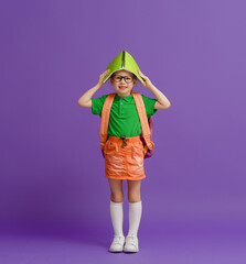 Kid with backpack on color background.