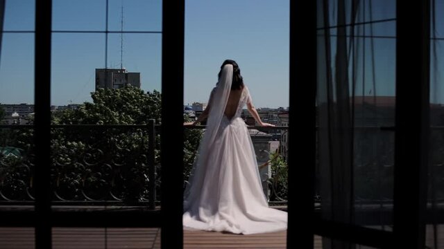 the bride on the balcony looks at the city