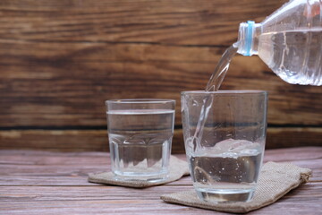 pouring water into glass on wood table 