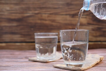 Glasses of water on a wooden table background and space for text