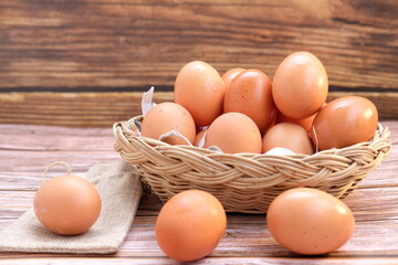 Eggs in basket on wood table background and space for text 