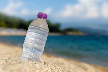 Bottle of fresh cold water on beach sand