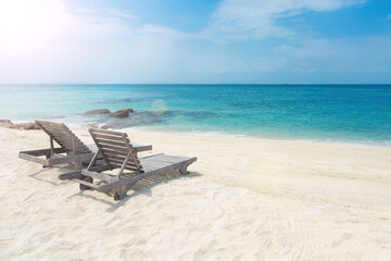 Two wooden sunbeds on paradise tropical beach. Relaxing, quite, romantic atmosphere on beautiful seashore. Holidays in summer time. Koh Munnork private island, Rayong province, Thailand.