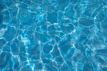 Fototapeta na wymiar Surface of Blue ripped water in the swimming pool. Background of water in the swimming pool.