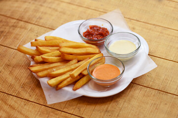 Tasty french fries on wooden table background