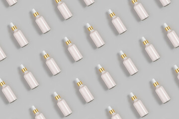 Cosmetic pattern. Pink anti-aging collagen, facial serum in transparent glass bottle with gold...