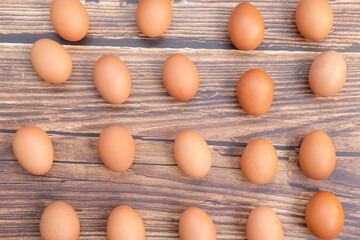 Chicken eggs in basket on wood table background and space for text