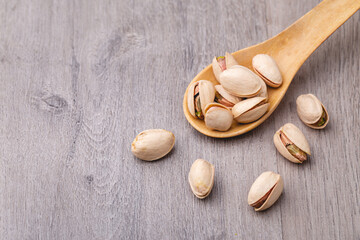Pistachio with spoon on wooden table