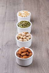 Mix Nuts in the glass on wooden background close up , peanut peas seeds pumpkin seeds , pistachios