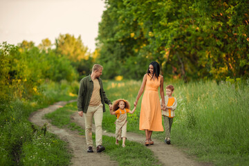 Happy international family on a summer walk in the park.