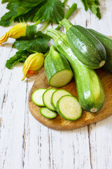 Fresh healthy uncooked green zucchini on a wooden kitchen table. Diet menu concept. Copy space.