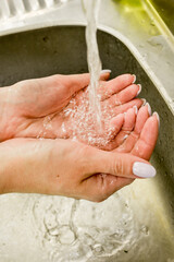 Woman use soap and washing hands under the water tap. Hygiene concept hand detail.