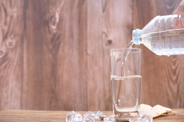 Drink water pouring into glass on wood table and space for text