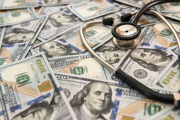 Doctor or nurse stethoscope on dollar banknotes