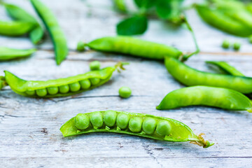 Fresh green peas on a wooden background.