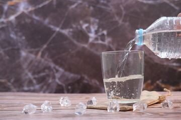 Pouring drinking water on wooden table background and space for text 