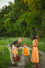 Happy international family on a summer walk in the park.