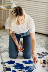 Beautiful young woman artist drawing in a comfy home interior