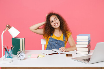 Pensive african american girl employee in office sit work at desk isolated on pink background. Achievement business career. Education in school university college concept. Put hand on head looking up.