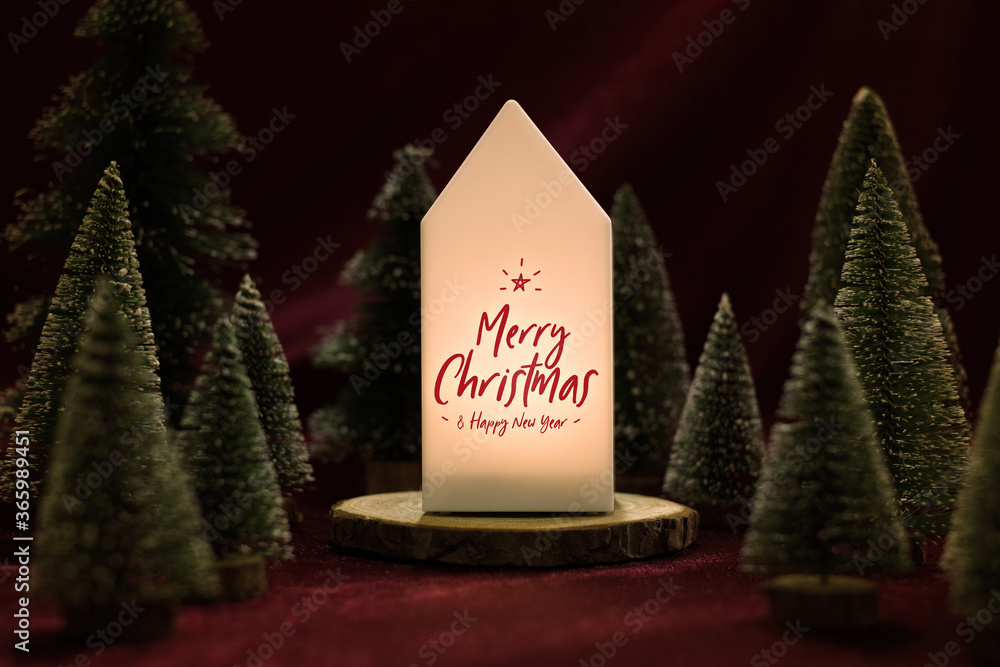 Poster merry christmas and happy new year text on home lamp with xmas tree on red velvet fabric table in da