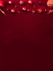 red christmas decoration bauble and ribbon on velvet red felt fabric  top view table backgorund.vertical layout
