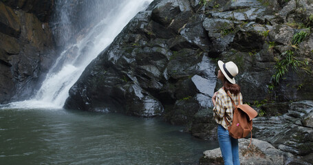 Woman look at the waterfall in forest