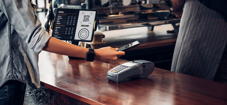 customer contactless payment for drink with mobile phon at cafe counter bar,seller coffee shop accept payment by mobile.new normal lifestyle concept