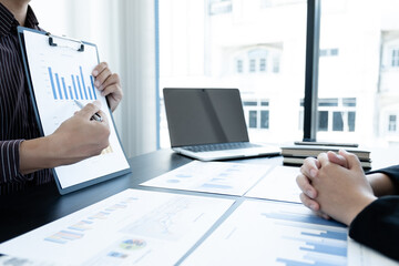 Two business leaders discussing the charts and graphs showing the results, Planning to start a new strategy for big success In the office