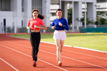 Obraz premium Young fitness woman runner jogging excercise in the morning on city stadium track in the city. Female athlete excercise in the city stadium to keep body fitness. Stock photo.
