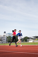 Fototapeta premium Young fitness woman runner jogging excercise in the morning on city stadium track in the city. Female athlete excercise in the city stadium to keep body fitness. Stock photo.