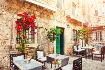 Fototapeta na wymiar Cafe on the street in Old Town in Kotor, Montenegro. Famous travel destination