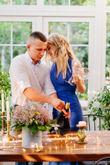 love happy couple on romantic dinner with glass. guy pours champagne.