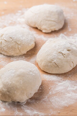 Freshly prepared yeast dough for pizza or bread on wooden background.