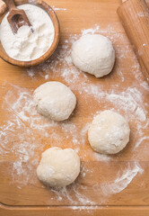 Freshly prepared yeast dough for pizza or bread on wooden background.