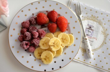 Top view of food fruit plate. Plate with strawberry, raspberry and sliced banana.