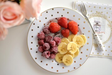 Top view of food fruit plate. Plate with strawberry, raspberry and sliced banana.