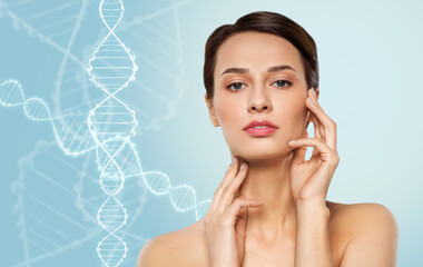 beauty, technology and genetics concept - beautiful young woman touching her face and neck skin over dna molecules on blue background