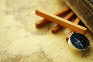 Travel and adventure search concept. Vintage aged map with a shabby book and compass. Shabby book and compass on the table.