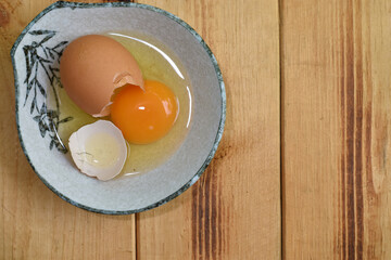 Egg yolks and eggs in a ceramic bowl