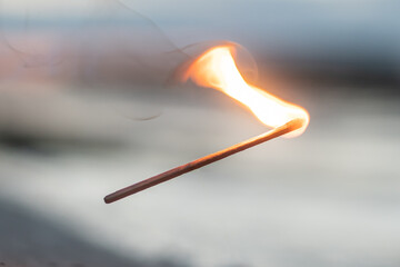 Burning match falls in the evening, close up.