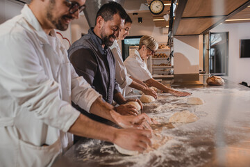 Group of bakers examine quality of dough for baking bread in modern manufacturing.