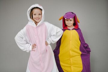 two beautiful girls dressed as rabbit and dragon posing in front of grey background